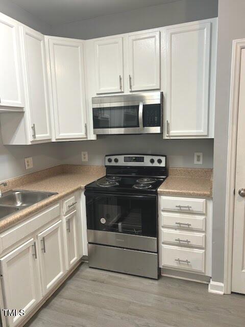350 Gilman Lane, Unit 108 Raleigh, NC 27610 - Photo 9 of 34 a kitchen with stainless steel appliances granite countertop white cabinets and a stove top oven