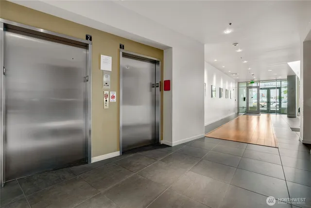 a room with stainless steel appliances kitchen island granite countertop a refrigerator and a sink