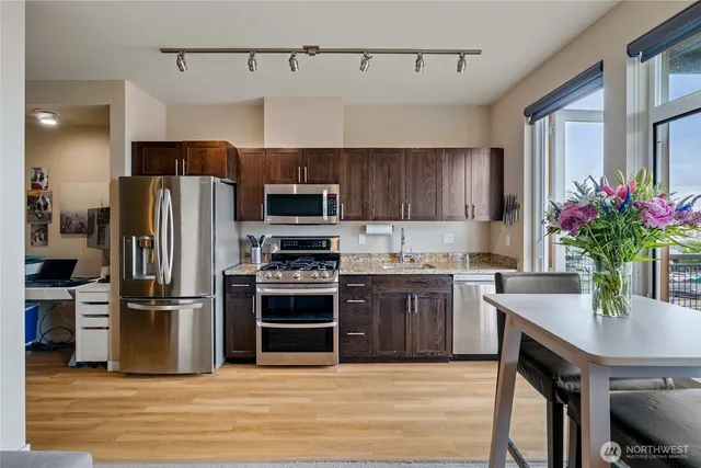 a kitchen with kitchen island a counter space a sink appliances and cabinets