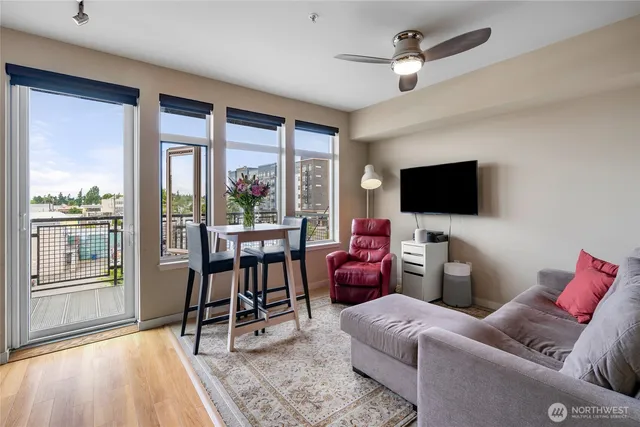 a living room with furniture a flat screen tv and floor to ceiling windows