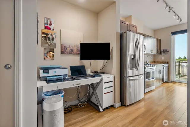 a kitchen with stainless steel appliances a stove top oven a refrigerator and a view of living room