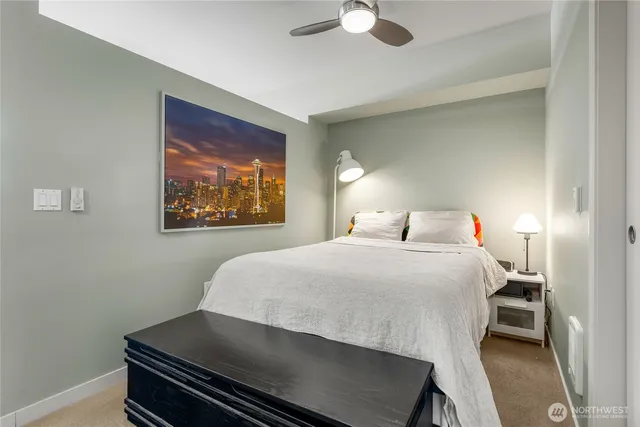 a bedroom with a bed and a painting on the wall