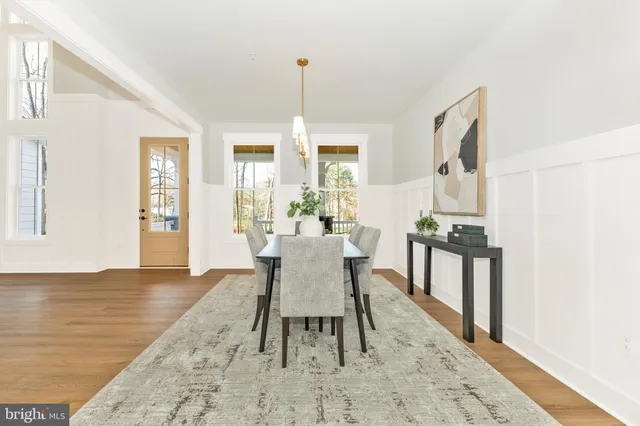 a dining room with furniture window and wooden floor