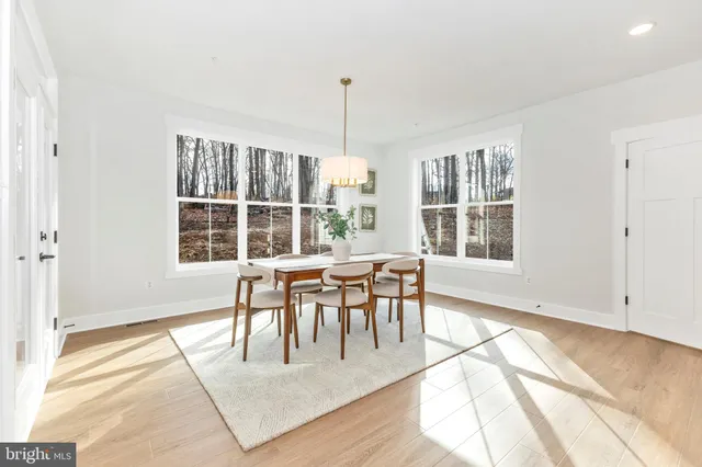a dining room with stainless steel appliances kitchen island a table and chairs