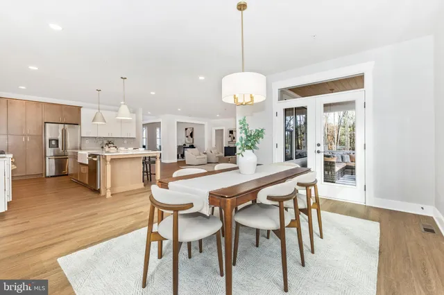 a dining room with furniture potted plants and wooden floor