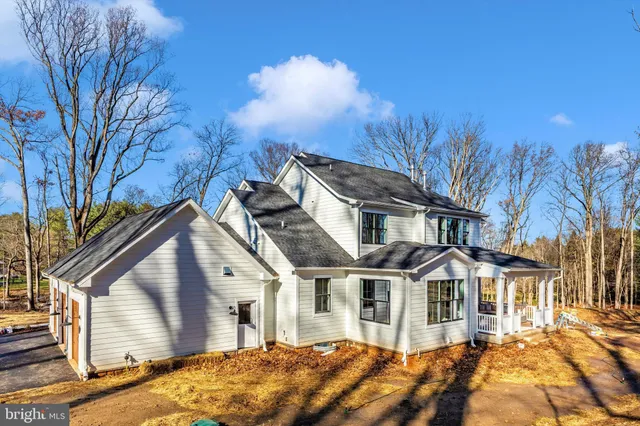 a front view of a house with a yard and trees