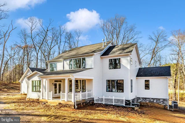 a front view of a house with a yard covered with snow