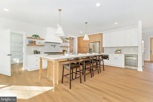 a kitchen with stainless steel appliances kitchen island granite countertop a table chairs and a refrigerator