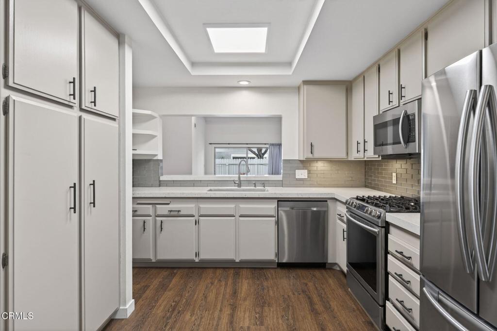 449 Reed Way Port Hueneme, CA 93041 - Photo 13 of 42 a kitchen with stainless steel appliances a sink cabinets and wooden floor