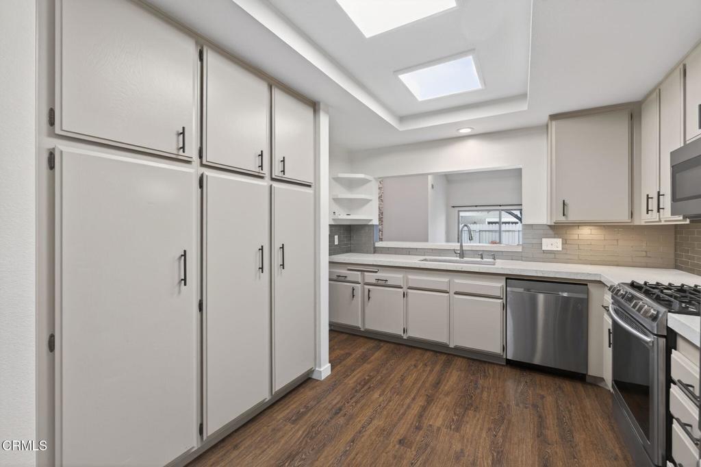 449 Reed Way Port Hueneme, CA 93041 - Photo 14 of 42 a kitchen with white cabinets and white appliances