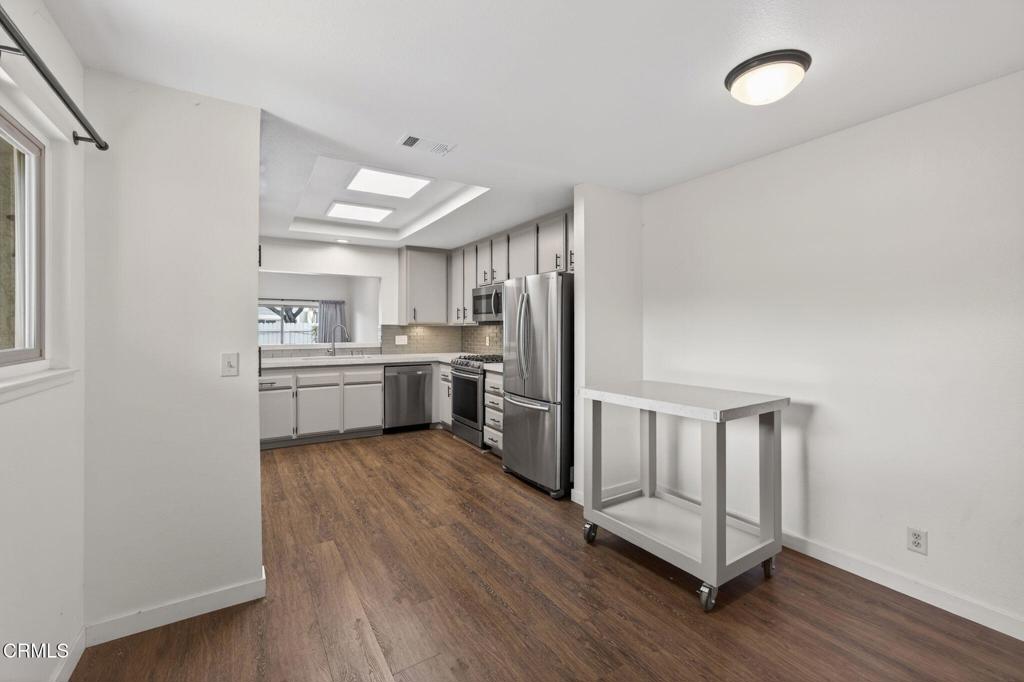 449 Reed Way Port Hueneme, CA 93041 - Photo 17 of 42 a kitchen with white cabinets and wooden floor