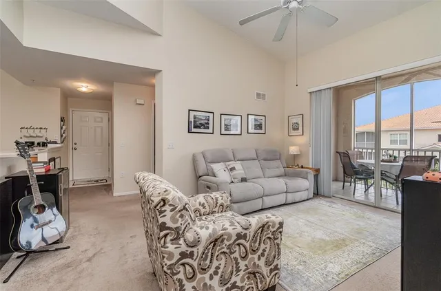 a living room with furniture and a floor to ceiling window