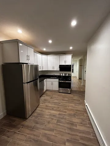 an empty room with wooden floor and entrance