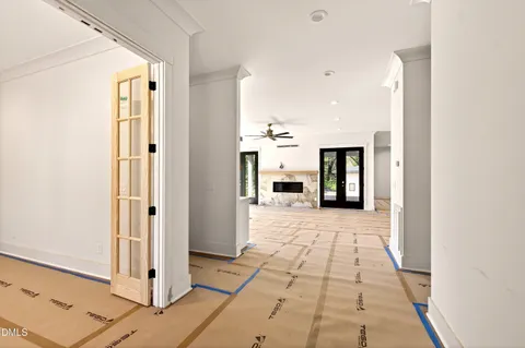 a view of a hallway with wooden floor and a kitchen