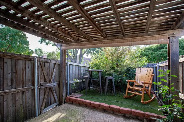 a view of backyard with wooden fence and a large tree