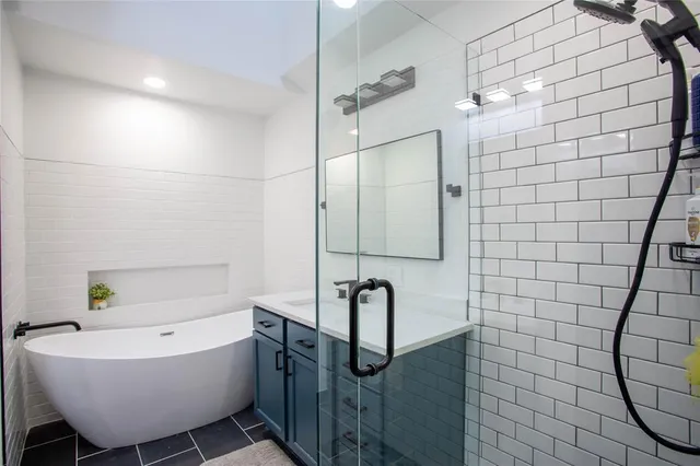 a bathroom with a bathtub sink shower and mirror