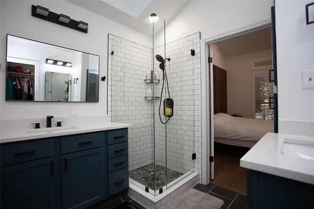 a bathroom with a sink a toilet a mirror and shower