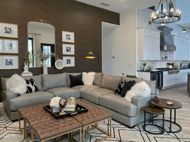 a living room with furniture kitchen view and a chandelier