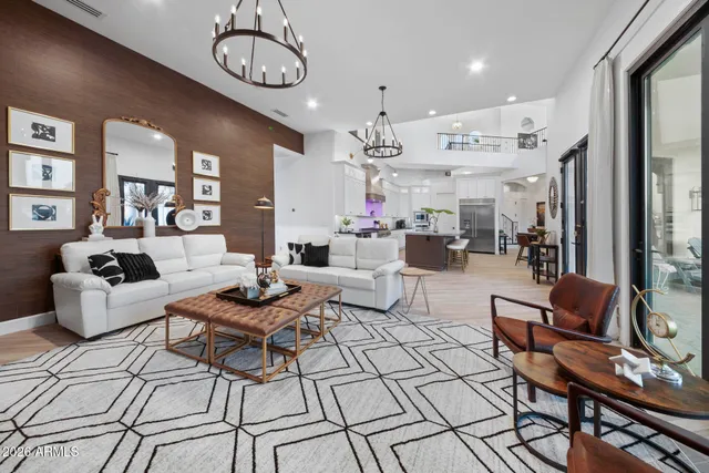 a living room with furniture a chandelier and a flat screen tv