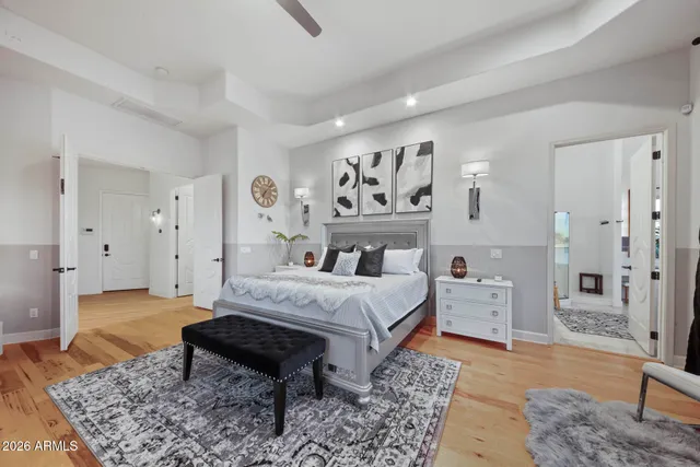 a bed sitting in a bedroom next to a painting on the wall