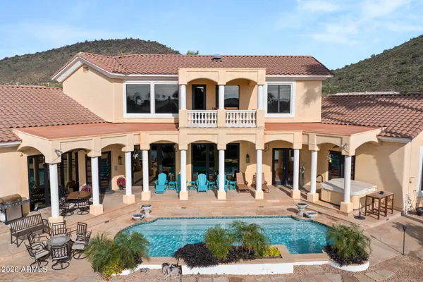 a view of a white house with large windows next to a yard