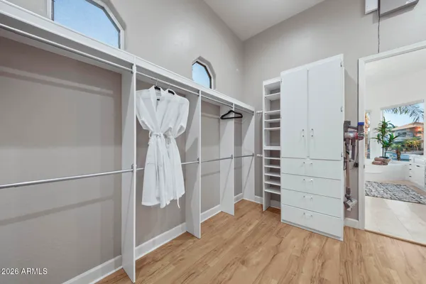 a spacious bedroom with a bed and a flat screen tv