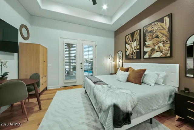a bedroom with a beds chandelier and a window