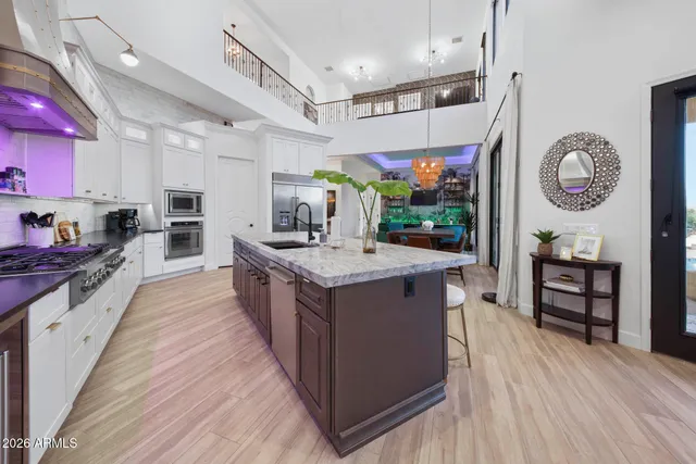 a kitchen with granite countertop a sink a stove and a wooden floor