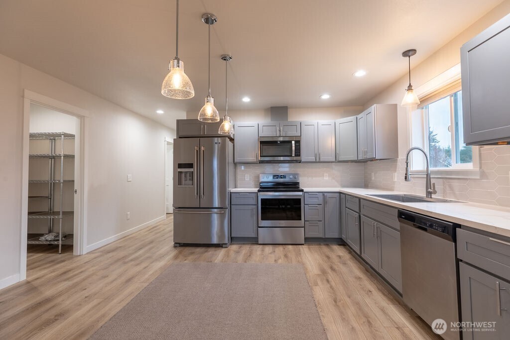 997 King Johns Way Forks, WA 98331 - Photo 19 of 39 a kitchen with stainless steel appliances a refrigerator sink and microwave