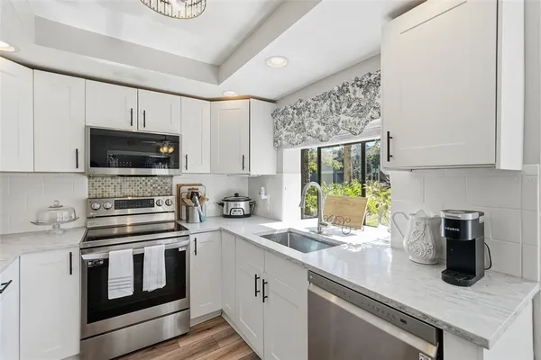a kitchen with a sink stove and microwave