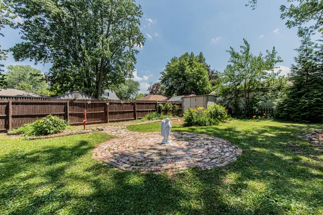 a front view of a house with a garden and trees