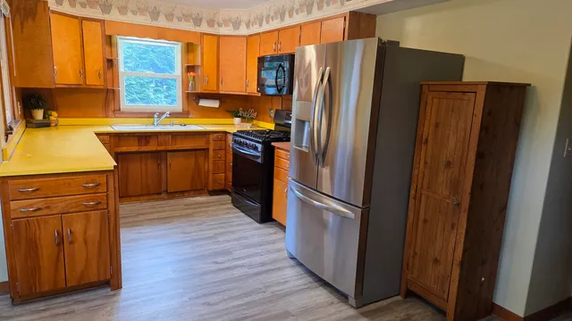 a kitchen with a refrigerator sink and wooden floor