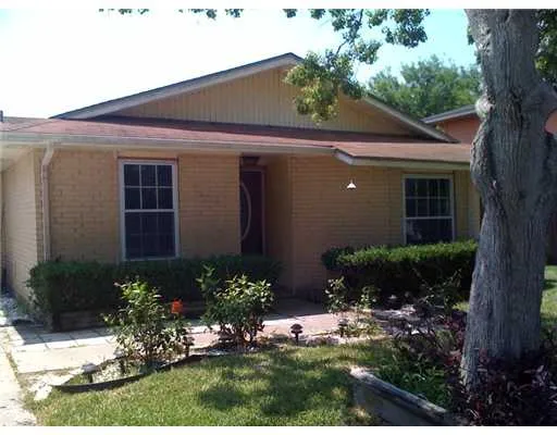 a view of a house with a yard and potted plants