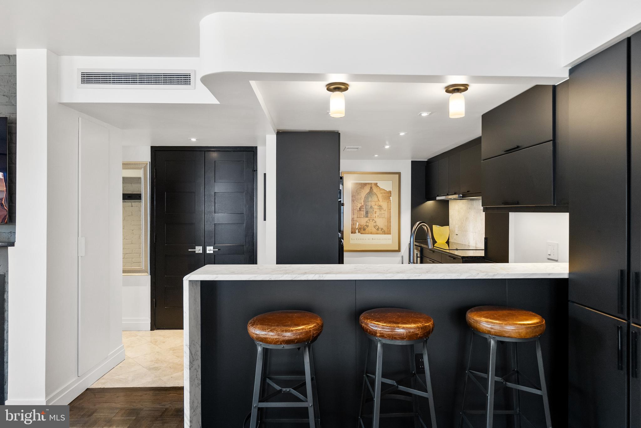 3210 Grace Street Northwest, Unit 304 Washington, DC 20007 - Photo 12 of 41 a kitchen with stainless steel appliances kitchen island a table and chairs in it