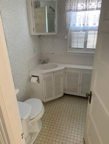 a bathroom with a sink a toilet and a window