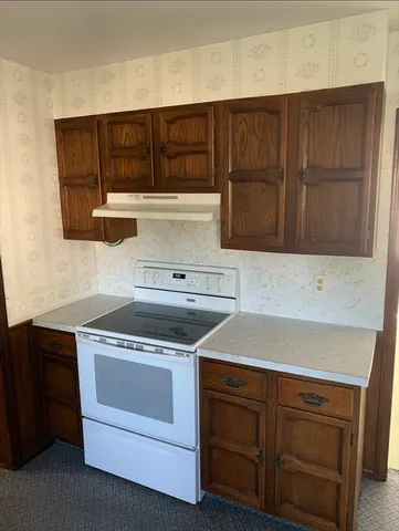 a kitchen with granite countertop cabinets and white stove