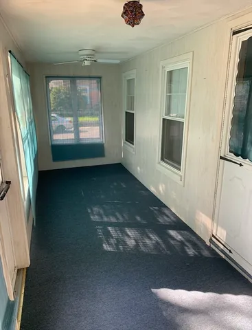 a view of an empty room with a fireplace and a window