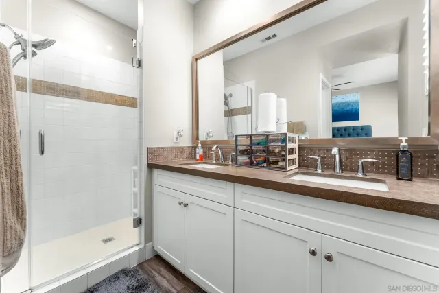 a bathroom with double sink and a mirror