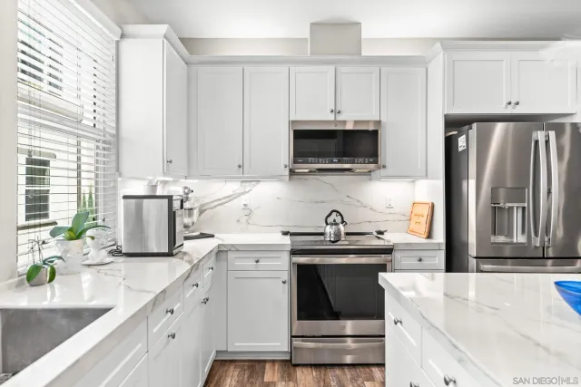 a kitchen with kitchen island granite countertop a sink stainless steel appliances and cabinets