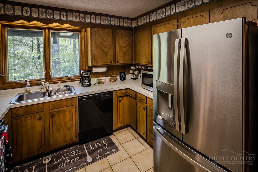107-109 Shagbark Road Beech Mountain, NC 28604 - Photo 19 of 45 a kitchen with a refrigerator a sink and cabinets