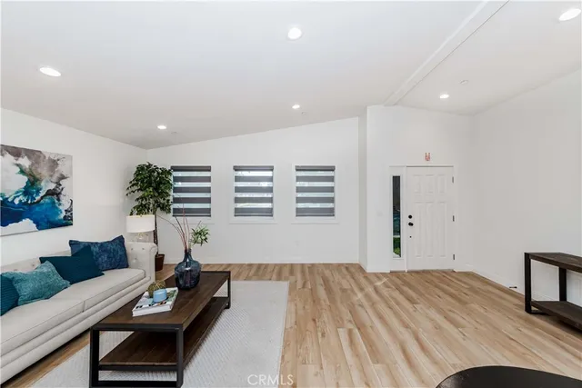 a kitchen with stainless steel appliances granite countertop a dining table chairs and white cabinets