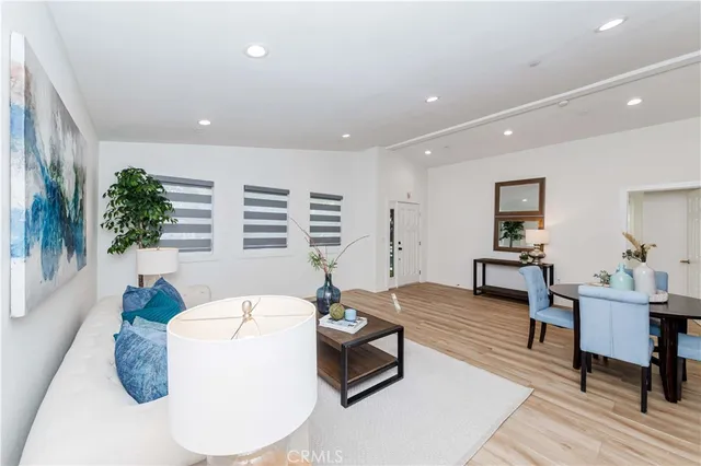 a kitchen with stainless steel appliances kitchen island granite countertop a table chairs and a refrigerator