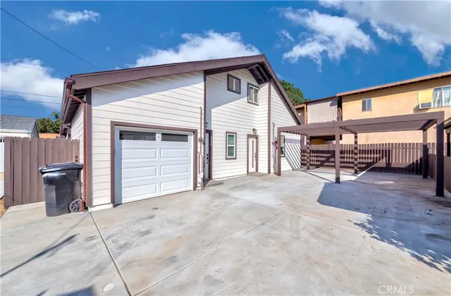 a view of a house with backyard and sitting area