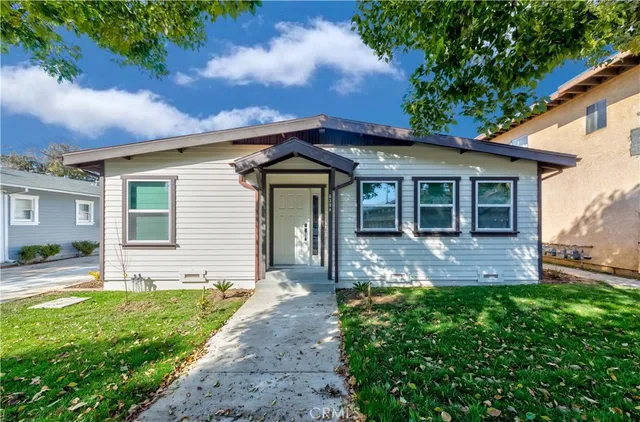 a view of a house with a yard and sitting area