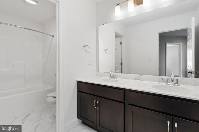 a bathroom with a double vanity sink toilet and shower