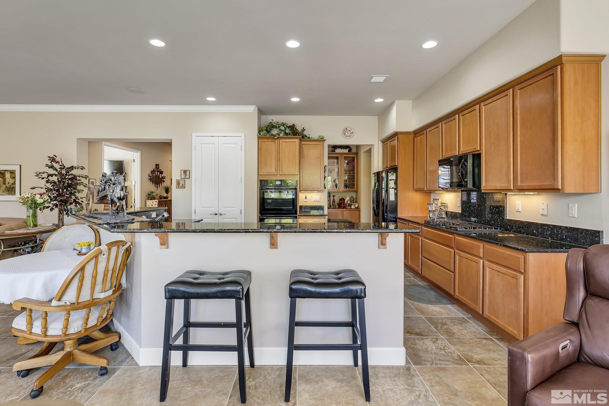 1320 Winterchase Way Reno, NV 89523 - Photo 14 of 37 a kitchen with stainless steel appliances granite countertop a stove a sink a oven a dining table and chairs