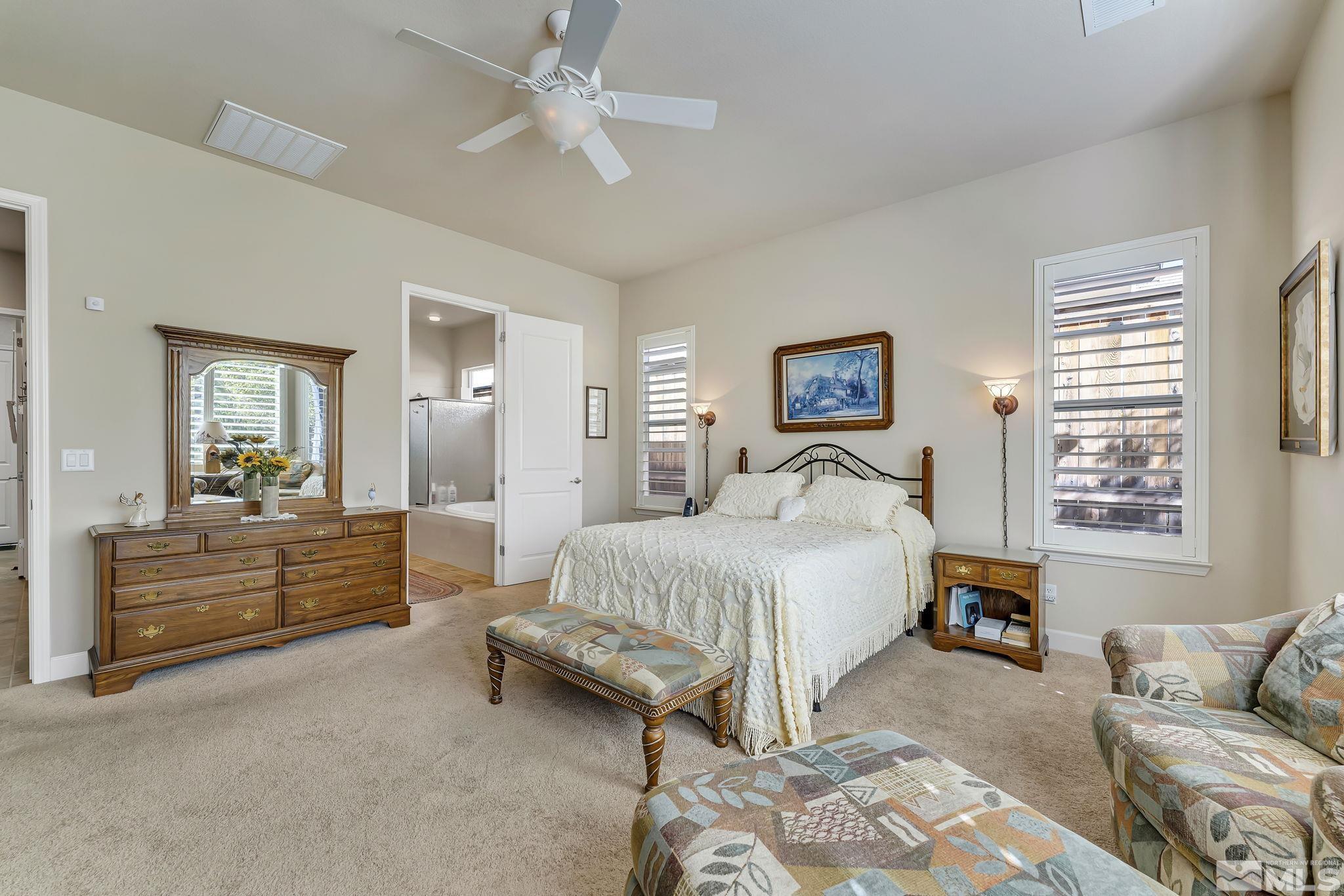 1320 Winterchase Way Reno, NV 89523 - Photo 20 of 37 a spacious bedroom with a bed a couch and large windows