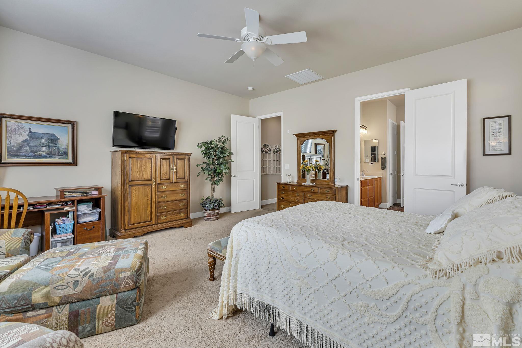 1320 Winterchase Way Reno, NV 89523 - Photo 21 of 37 a spacious bedroom with a bed and a flat screen tv
