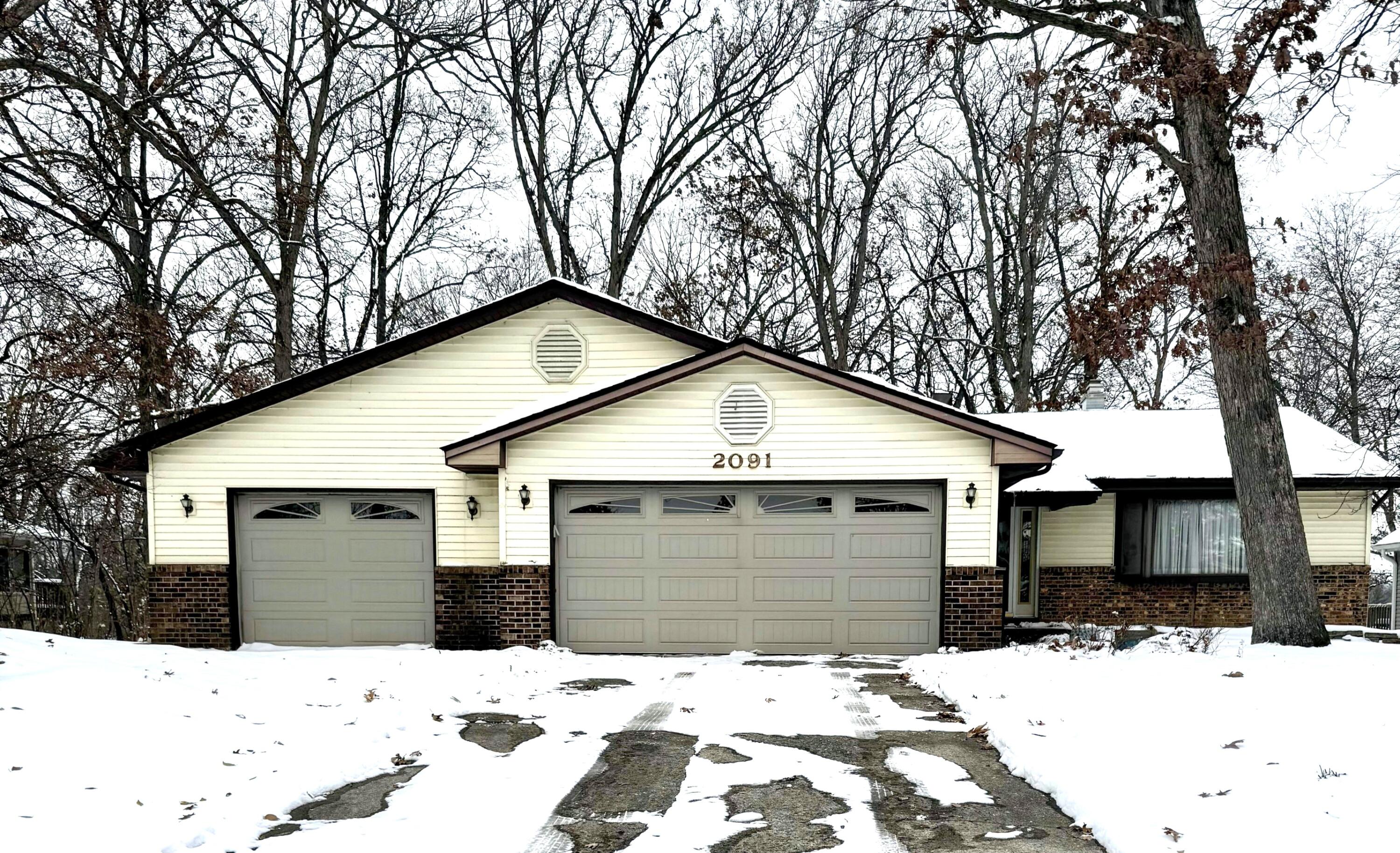 2091 Hidden Valley Drive Crown Point, IN 46307 - Photo 2 of 38 a front view of a house with a yard covered in snow