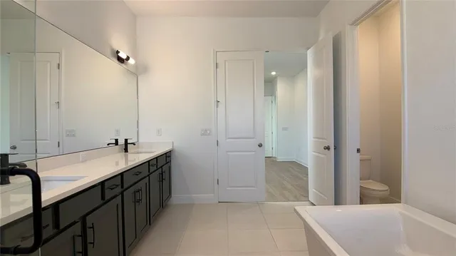 a spacious bathroom with a bathtub sink and mirror